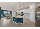 Open kitchen with white cabinets, blue island, and stainless steel appliances at 10043 Crooked Creek Dr # 202, Venice, FL 34293