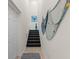 Interior view of a staircase with dark carpeting and coastal wall decor at 10043 Crooked Creek Dr # 202, Venice, FL 34293