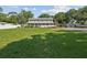 Large grassy yard with mature trees and a two-story house at 1055 Philippe Pkwy, Safety Harbor, FL 34695