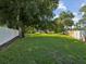 Long grassy side yard, bordered by a white fence at 1055 Philippe Pkwy, Safety Harbor, FL 34695