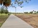 Concrete walkway in a park setting with trees and benches at 1055 Philippe Pkwy, Safety Harbor, FL 34695
