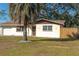 Tan house with brown roof, palm tree, and fenced yard at 11129 101St Ave, Seminole, FL 33772