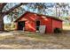 Red barn with double doors and screen door at 12519 Fairwinds Rd, Hudson, FL 34669