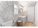 Modern bathroom with gray vanity, gold accents, and palm leaf wallpaper at 15804 Redington Dr, Redington Beach, FL 33708