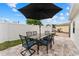 Outdoor patio with dining table set for six under an umbrella at 15804 Redington Dr, Redington Beach, FL 33708