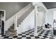 A view of the home's grand staircase and entryway with checkerboard flooring at 1598 Lockmeade Pl, Oldsmar, FL 34677