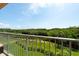 Balcony view of water, lush landscape, and blue skies at 1695 Pinellas Bayway S # E4, Tierra Verde, FL 33715