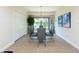 Bright dining room with modern table and chairs, hardwood floor, and large windows at 1695 Pinellas Bayway S # E4, Tierra Verde, FL 33715