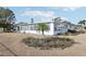 White house with a sunroom and garden at 1732 Flamingo Ln, Sun City Center, FL 33573