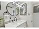Updated bathroom featuring a sleek vanity and modern round mirror at 200 1St Ave # 312, St Pete Beach, FL 33706