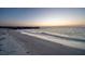 Scenic beach view with a distant pier and the ocean extending to the horizon at 200 1St Ave # 312, St Pete Beach, FL 33706