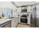Bright kitchen featuring white cabinets, stainless steel appliances, and a view of the ocean at 200 1St Ave # 312, St Pete Beach, FL 33706