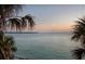 Breathtaking waterfront view, framed by palm trees, offering serenity and a tropical ambiance at 200 1St Ave # 312, St Pete Beach, FL 33706