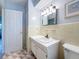 Bathroom with beige tile, vanity, and hexagonal floor tiles at 2148 Cunningham Dr, Clearwater, FL 33763