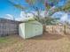 Tan metal storage shed in the backyard, behind a wooden fence at 2148 Cunningham Dr, Clearwater, FL 33763