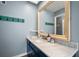 Bathroom with a large vanity mirror and blue cabinets at 2215 1St St, Indian Rocks Beach, FL 33785