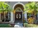 Double door entry with circular window and lush landscaping at 512 Creekside Ct, Safety Harbor, FL 34695