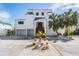 Two story home with white exterior, metal roof, and landscaped yard at 519 Loquat Dr, Anna Maria, FL 34216