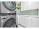 Modern laundry room with white cabinets and stacked washer/dryer at 519 Loquat Dr, Anna Maria, FL 34216