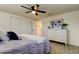 A bedroom with a view to an adjacent bathroom boasts wood-look tile floors, a ceiling fan and a neutral color palette at 5201 Cicero Dr, New Port Richey, FL 34652