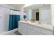 Bathroom with double vanity, shower, and teal shower curtain at 5462 Logan Cave Ave, Wimauma, FL 33598