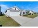 One-story house with white and gray exterior, two-car garage, and landscaping at 5462 Logan Cave Ave, Wimauma, FL 33598
