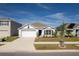 One-story house with white exterior, two-car garage, and landscaping at 5462 Logan Cave Ave, Wimauma, FL 33598
