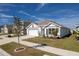 One-story house with white and gray exterior, two-car garage, and landscaping at 5462 Logan Cave Ave, Wimauma, FL 33598