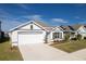 Charming one-story house with white and gray exterior, two-car garage at 5462 Logan Cave Ave, Wimauma, FL 33598