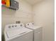 Bright laundry room features washer, dryer, and shelving at 5462 Logan Cave Ave, Wimauma, FL 33598