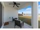 Covered patio with wicker chairs overlooking backyard at 5462 Logan Cave Ave, Wimauma, FL 33598