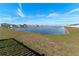 Serene pond view, lush green grass, and clear sky at 5462 Logan Cave Ave, Wimauma, FL 33598