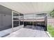 Backyard patio with screened enclosure and wooden fence at 5836 8Th St, Zephyrhills, FL 33542