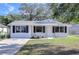 Charming newly painted white house with black shutters and a well-manicured lawn at 5836 8Th St, Zephyrhills, FL 33542