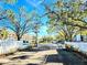 Community entrance with white fence and trees at 6188 80Th N St # 402, St Petersburg, FL 33709