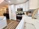 Updated kitchen with white cabinets, quartz countertops, and gold accents at 6188 80Th N St # 402, St Petersburg, FL 33709