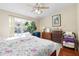 Bright bedroom with floral bedding, dresser, and window at 6333 Osprey Lake Cir, Riverview, FL 33578