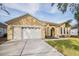 House exterior showcasing a two-car garage and landscaping at 13029 Haverhill Dr, Spring Hill, FL 34609