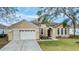 House exterior with two-car garage and well-manicured lawn at 13029 Haverhill Dr, Spring Hill, FL 34609