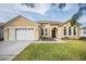 House exterior with a two-car garage and landscaped yard at 13029 Haverhill Dr, Spring Hill, FL 34609