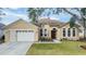 House exterior featuring a two-car garage and a well-maintained lawn at 13029 Haverhill Dr, Spring Hill, FL 34609