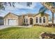 House exterior featuring a two-car garage and well-manicured lawn at 13029 Haverhill Dr, Spring Hill, FL 34609