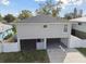 Modern house exterior with a gray facade, white fence, and attached garage at 1866 Michigan Ne Ave, St Petersburg, FL 33703