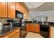 Modern kitchen with wood cabinets, granite counters and black appliances at 275 Bayshore Blvd # 408, Tampa, FL 33606