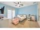 Light blue bedroom with double doors, ceiling fan, and desk at 27708 Indigo Pond Ct, Wesley Chapel, FL 33544