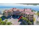 Aerial view of waterfront condo building with parking and palm trees at 2773 Via Cipriani # 1321B, Clearwater, FL 33764
