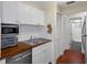 Updated kitchen with white cabinets, butcher block countertops, and stainless steel appliances at 314 Moorings Cove Dr, Tarpon Springs, FL 34689