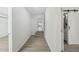 Hallway with light walls and wood-look floors, showing access to rooms and bath at 4318 1St S Ave, St Petersburg, FL 33711