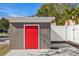 A red-doored storage shed sits in the backyard, offering extra storage space at 4318 1St S Ave, St Petersburg, FL 33711
