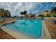 Community pool with lounge chairs and palm trees at 4725 Cove Cir # 211, St Petersburg, FL 33708